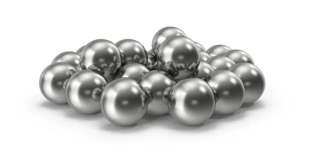 A pile of polished steel shot pellets on a white background